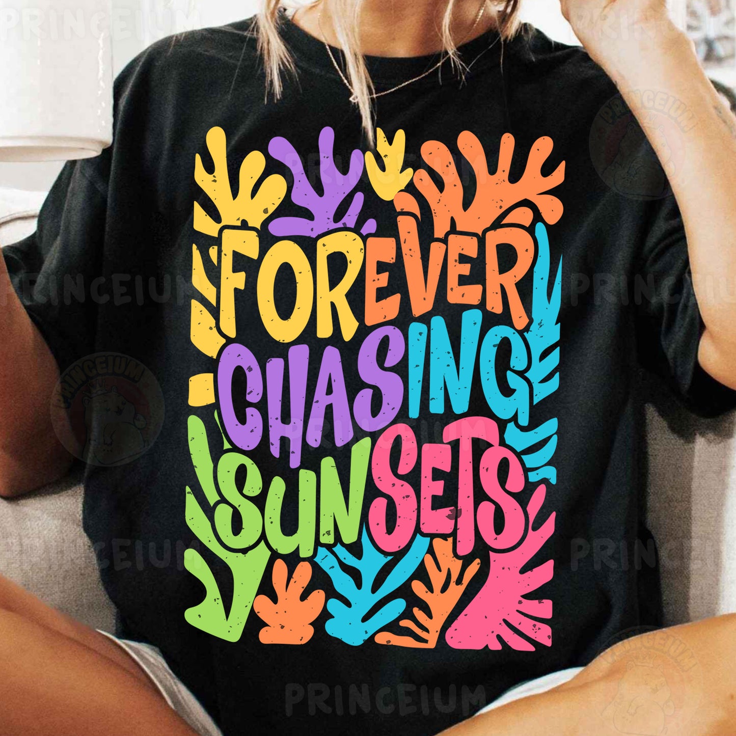 a woman sitting on a couch wearing a t - shirt that says forever chasing sunset