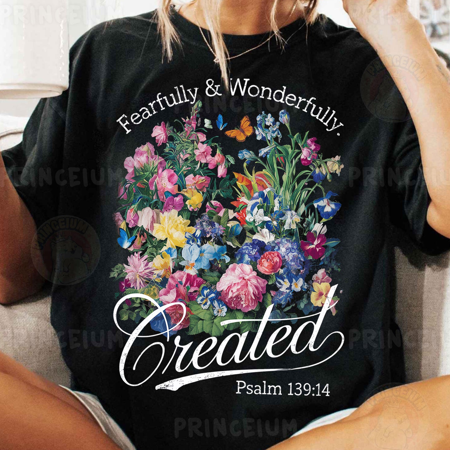 a woman sitting on a couch wearing a t - shirt with a picture of flowers