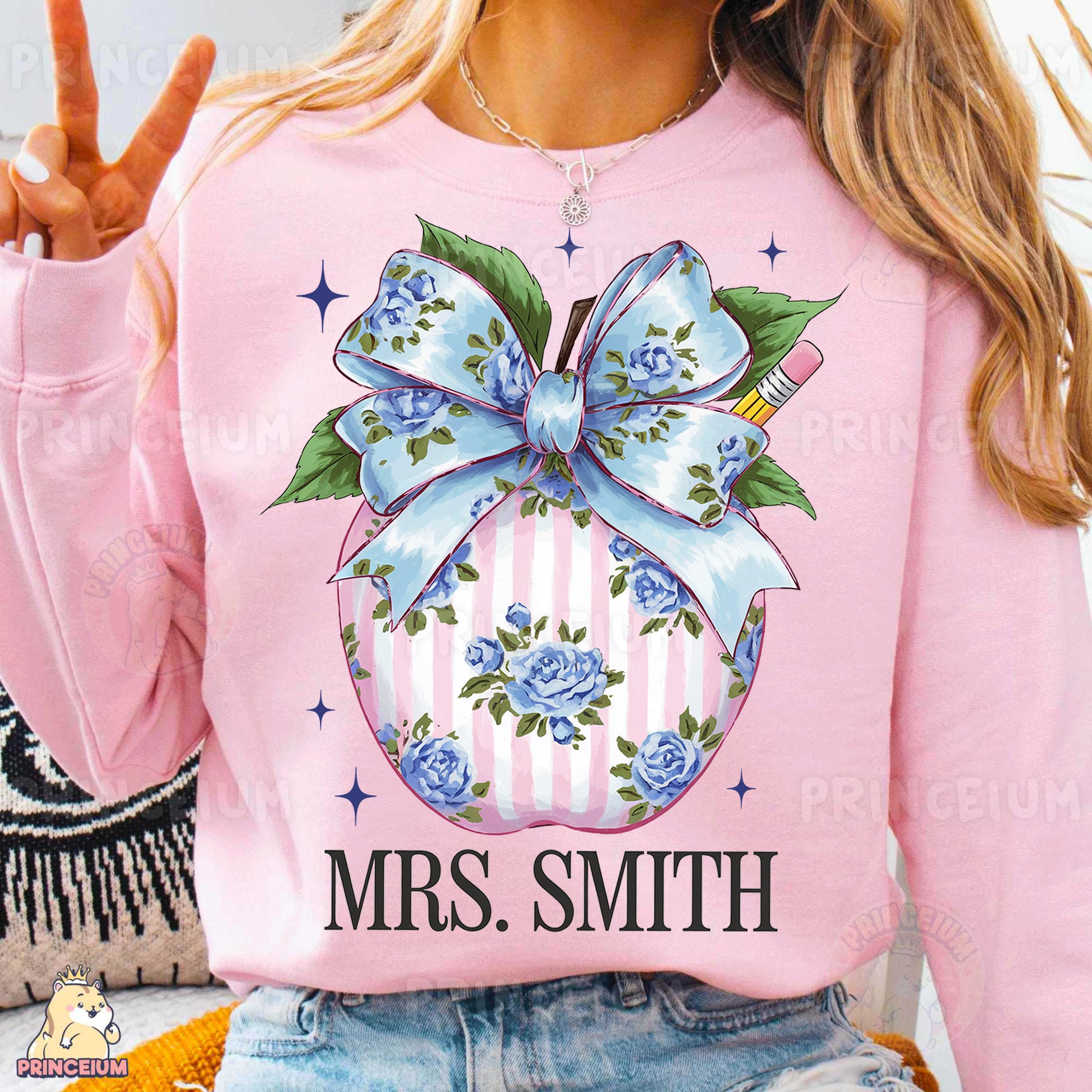 a woman wearing a pink sweater with a blue bow on it