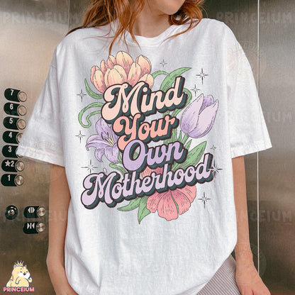 a woman wearing a t - shirt that says mind your own motherhood