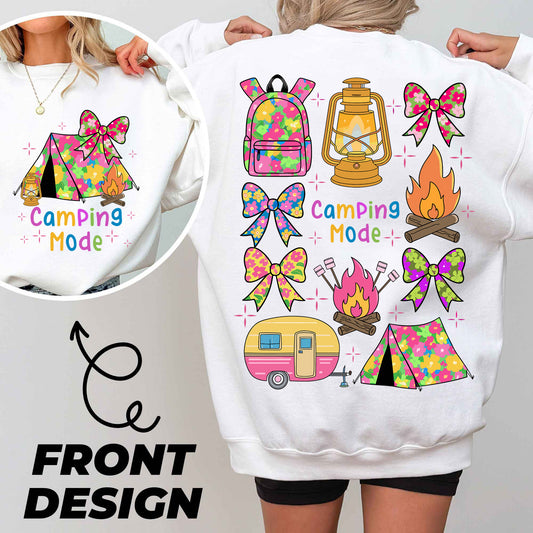 a woman wearing a white sweatshirt with camping designs on it