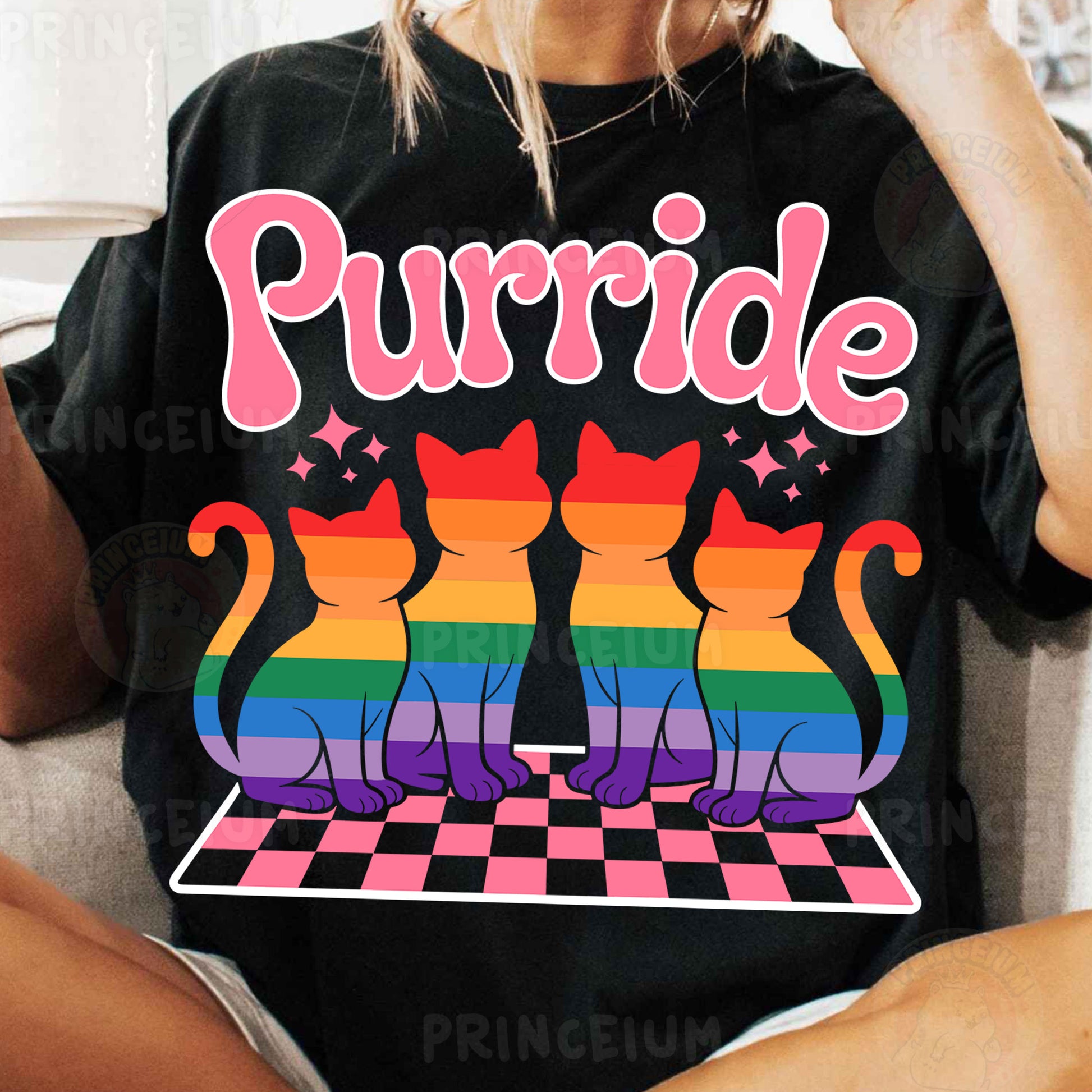 a woman sitting on a couch wearing a black shirt with a rainbow cat on it