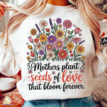 a woman wearing a t - shirt that says mothers plant seeds of love that bloom