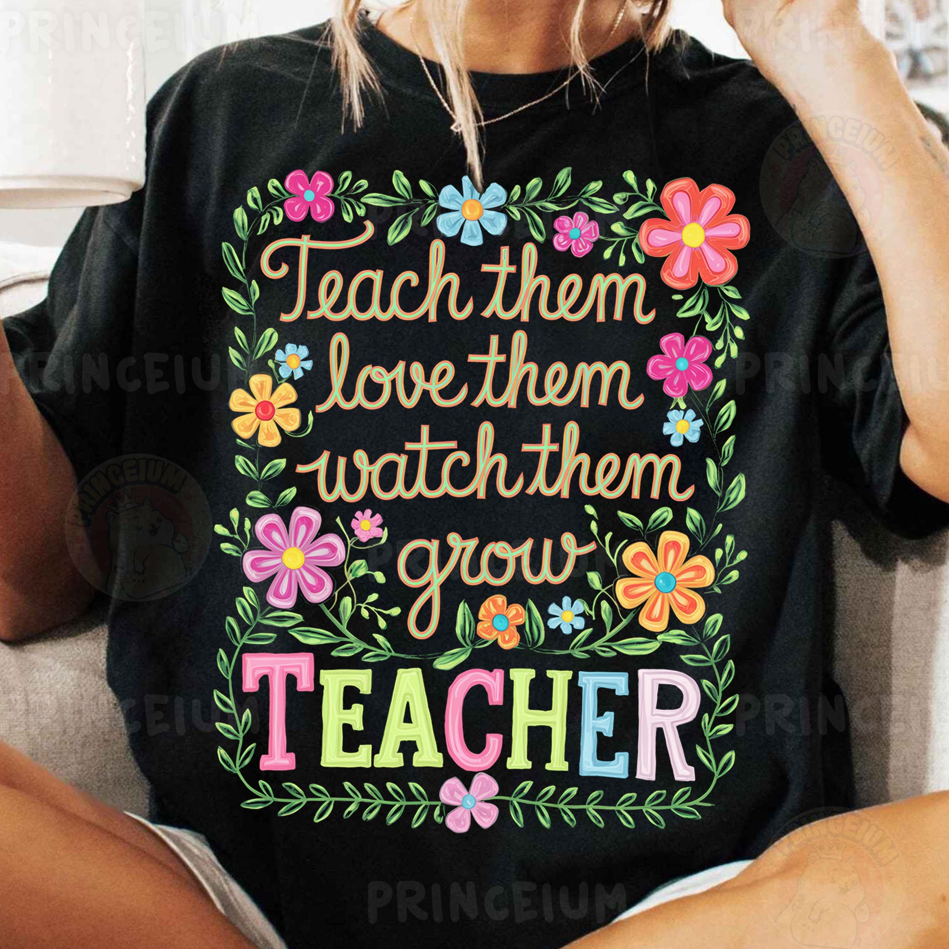 a woman sitting on a couch wearing a teacher shirt