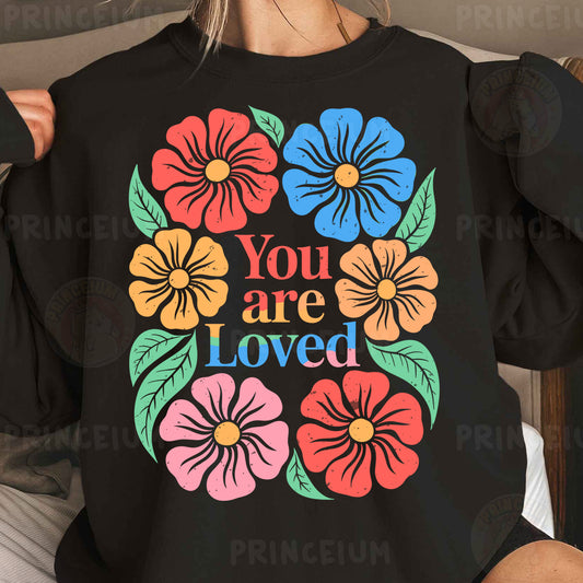a woman wearing a black sweatshirt with colorful flowers on it