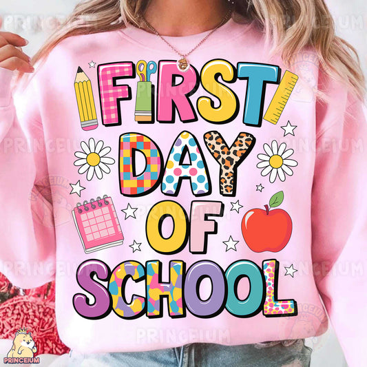 a woman wearing a pink sweatshirt that says first day of school