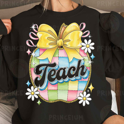a woman wearing a black teacher shirt with a yellow bow
