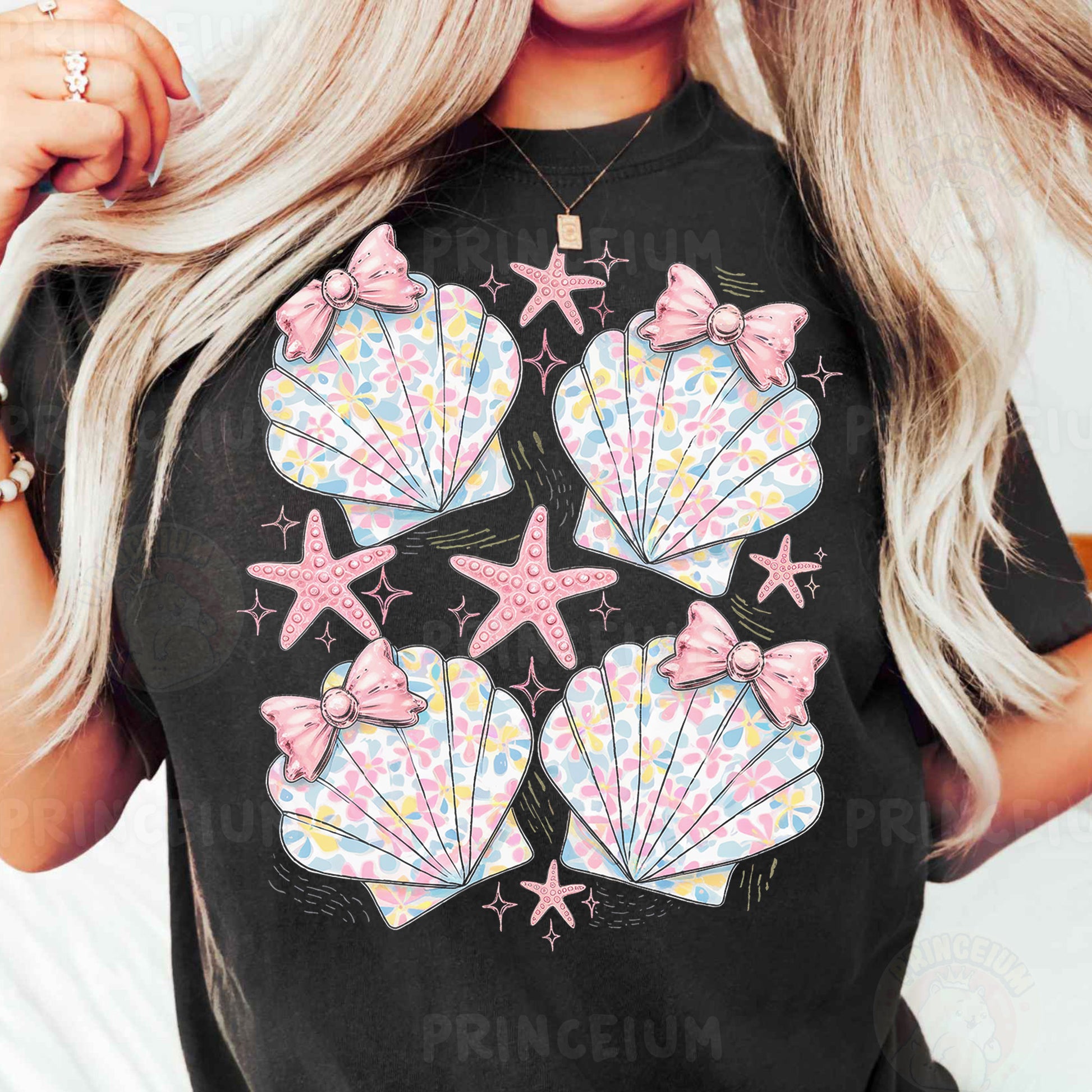 a woman wearing a black t - shirt with pink seashells and starfish