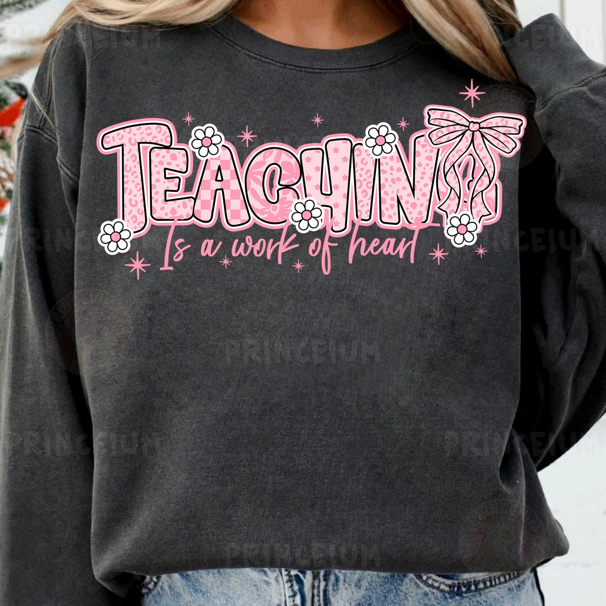 a woman wearing a black sweatshirt that says teaching is a work of heart