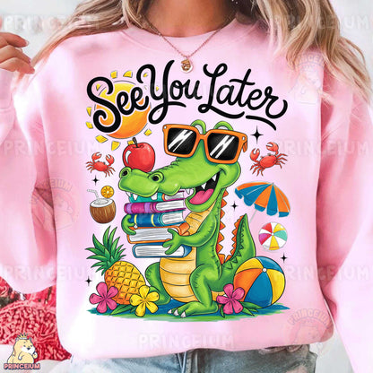 a woman wearing a pink sweatshirt with a graphic of a crocodile reading a book