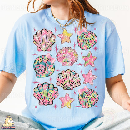 a young girl wearing a blue shirt with colorful seashells on it