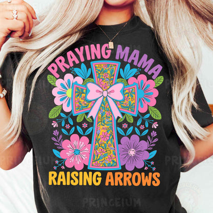 a woman wearing a t - shirt that says praying mama raising arrows