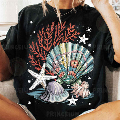 a woman sitting on a couch wearing a black shirt with a seashell and star