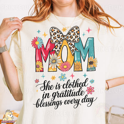 a woman wearing a t - shirt that says mom she is clothed in grati