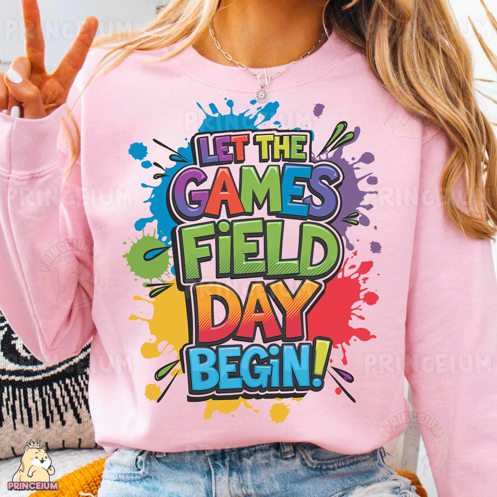 a woman wearing a pink sweatshirt that says let the games field day begin